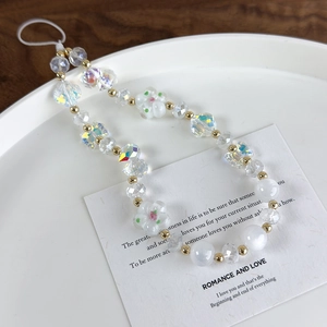 Detail shot of a handmade iridescent beaded phone strap with floral and AB finish beads