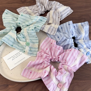 Détail de chouchous en tissu rayé coloré avec bordure en dentelle et boutons décoratifs
