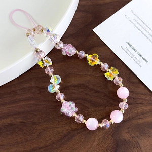 Detail showing pink beads and yellow butterfly charms on a beaded phone wrist strap