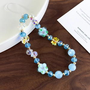 Detail of beaded phone strap with colorful glass beads flower and butterfly charms