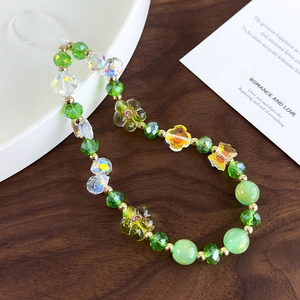 Close-up of handmade beaded phone strap featuring floral beads and butterfly charms