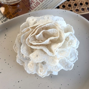 Close-up of sweet beige lace flower hair claw clip with delicate embroidery details