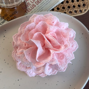 Detailed view of pink lace flower hair claw with elegant embroidery and layered fabric petals