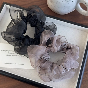 Detail of black and lavender organza scrunchies in a flat lay decorative setting