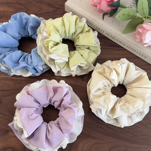 Set di quattro elastici per capelli colorati con pizzo su tavolo di legno