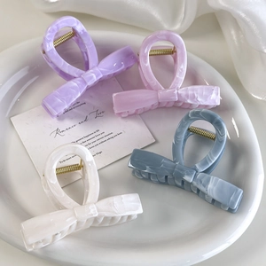 Detailed macro view of colorful jelly-tone bow hair clips with elegant marble textures