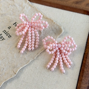 Vue détaillée des bijoux de chaussures avec nœuds en perles roses et pompons élégants