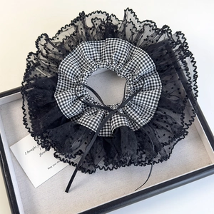 Detail of black and white lace scrunchie with gingham pattern and a small ribbon bow