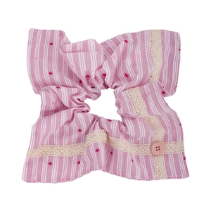 Détail d'un chouchou à rayures roses avec bordure en dentelle crème et bouton rose