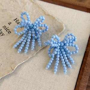 Détail des boucles de chaussures avec perles bleu clair et pampilles élégantes en ruban