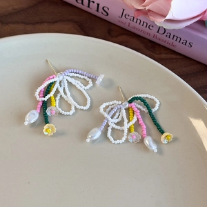 Boucles d'oreilles colorées en perles faites main avec pompon et fleur sur céramique