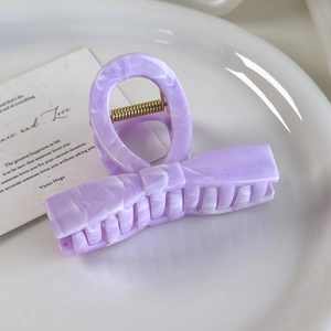 Detail of lavender marble texture hair claw clip on white ceramic plate with a card