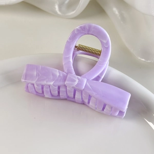 Detailed macro shot of purple marble pattern hair claw clip with metallic spring and silk