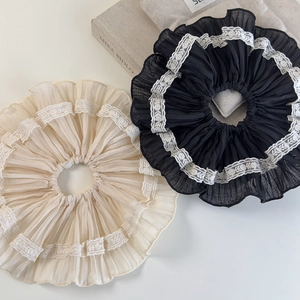 Elegant beige and black pleated lace scrunchies on a soft aesthetic background