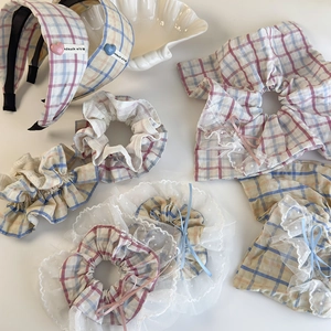 Pastel plaid scrunchies and lace headbands set with bows on a clean white background