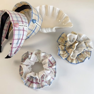 Detailed close-up of plaid scrunchies with white lace edges and heart decorated headbands