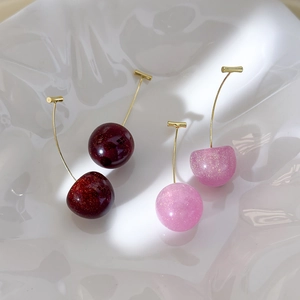 Cute resin cherry earrings in pink and deep red colors with glitter finish and gold posts
