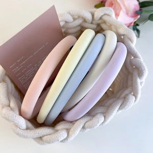 Set of five macrame pastel sponge headbands in a white woven basket with floral accents