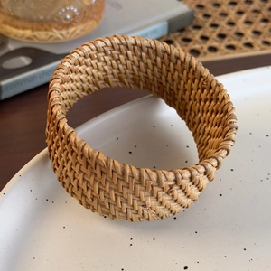 Détail macro du rond de serviette en rotin tressé à la main avec texture artisanale fine