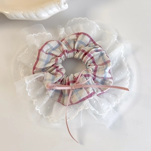 Detailed view of pink plaid scrunchie with delicate lace trim and ribbon bow