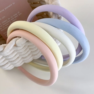Close-up of thick macaron colored sponge headbands in a basket showing soft fabric texture