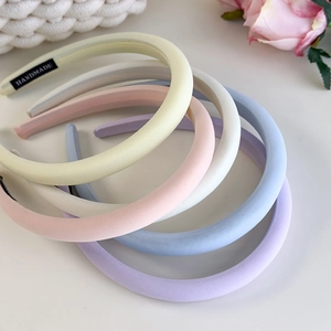 Close-up of colorful padded headbands with handmade label in cream macaron tones