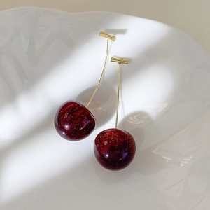 Detail of dark red cherry earring with gold glitter inside high-quality resin