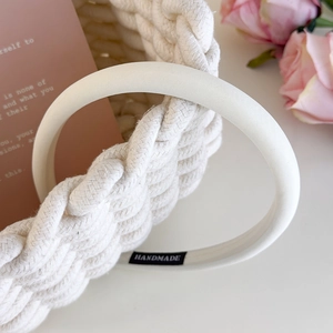 Detail view of handmade cream sponge headband with fabric texture and woven basket background