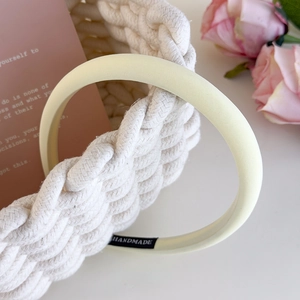Detail view of handmade cream velvet headband with a soft sponge padding and interior label