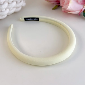 Close-up of handmade cream sponge headband with soft fabric texture and inner tag detail