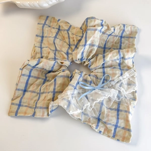Detail of sweet plaid hair scrunchie with lace edges and a blue satin ribbon bow