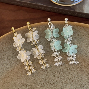 Detail of bohemian floral tassel earrings with frosted petals and crystal beads on ceramic