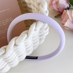Detail of lavender fabric headband with quality handmade label and twill texture finish