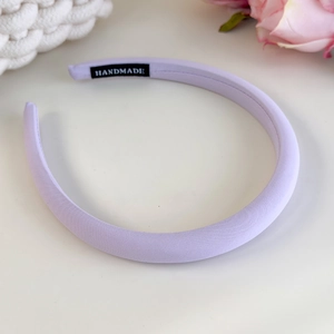 Detail of lilac fabric headband showing the handmade label and fine twill texture