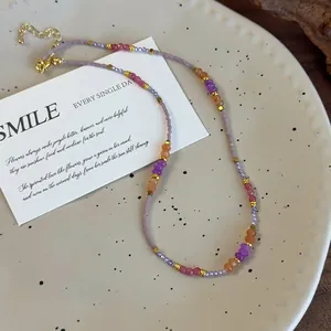 Collier artisanal perlé avec cristaux violets et orange dans un style bohème chic