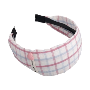 Detail of red and blue plaid headband with handmade label and pink heart charm
