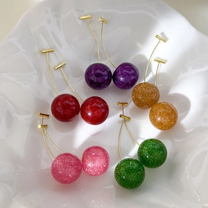 Detail of cherry resin earrings with colorful glitter in five vibrant translucent shades