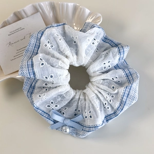Detail of blue plaid hair scrunchie with lace edge, ribbon bow and pearl pendant