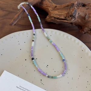 Détail d'un collier de perles colorées avec pierres en résine sur plateau