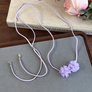 Détail du collier long floral violet avec cordon en daim et fleurs mates