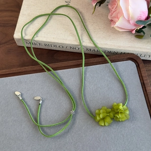 Détail du pendentif camélia givré sarcelle sur cordon en daim gris-vert style forêt