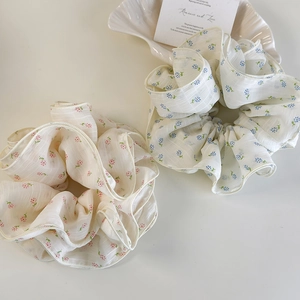 Floral oversized scrunchies in pink and blue floral patterns made of sheer organza fabric