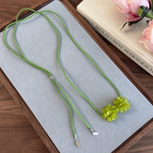 Détail du collier choker camélia vert style forêt avec pétales en résine et cordon daim