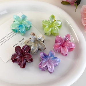 Set of 6 marble textured flower hair clips in various colors displayed on a white plate