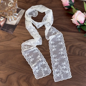 Close-up of white lace scarf with snowflake embroidery and Love lettering detail
