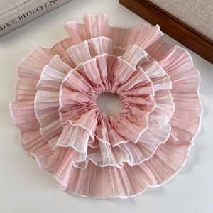 Detail of pink layered wavy edge scrunchie made of pleated chiffon with white piping trim