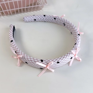 Détail du bandeau à carreaux roses avec petits cœurs et nœuds en soie élégants