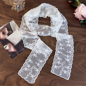 Detail of white lace skinny scarf with Love letters and floral pattern on wood
