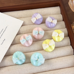 Pastellfarbene Emaille-Ohrstecker mit zarten Spitzenbögen auf einem Schmucktablett