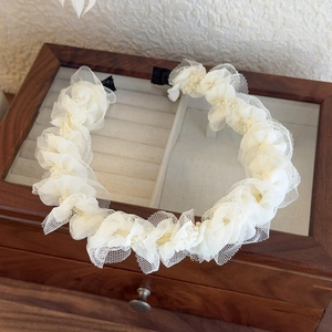 Dettaglio del cerchietto in pizzo bianco a strati con decorazioni di perle raffinate